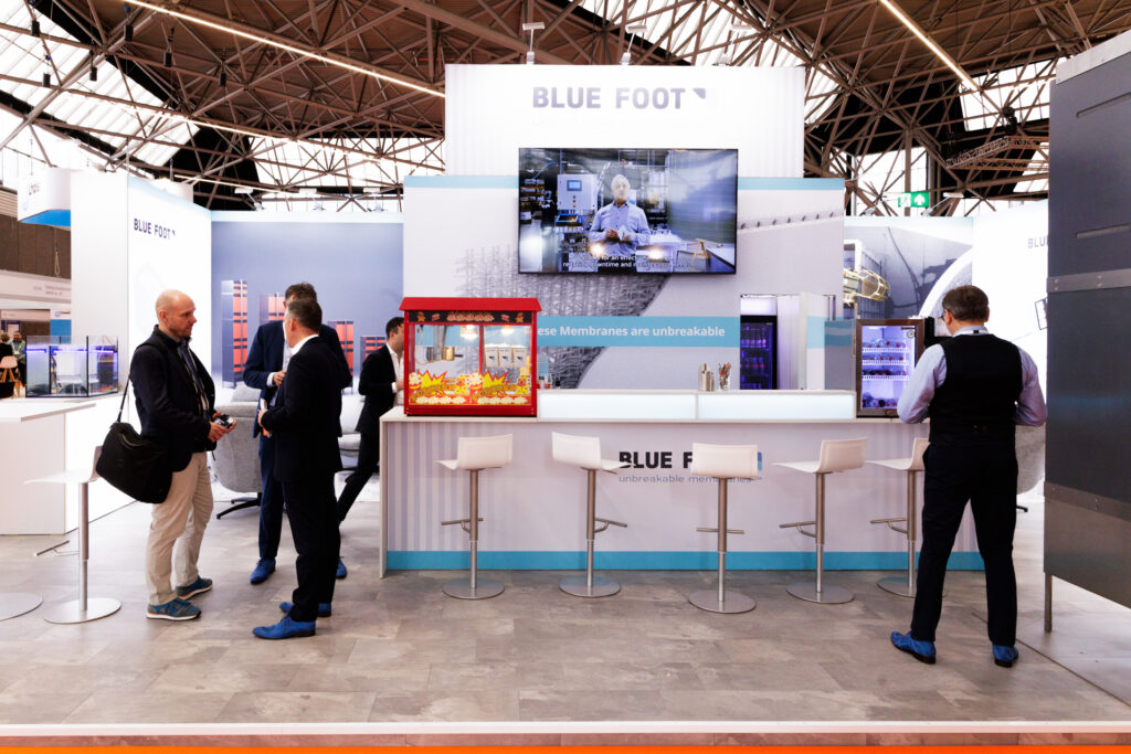 Eventfotografie Provada: Beursstand Blue Foot met mensen, bar, tv-scherm en popcornmachine. Groene Metropool. Joep van Drunen Photography