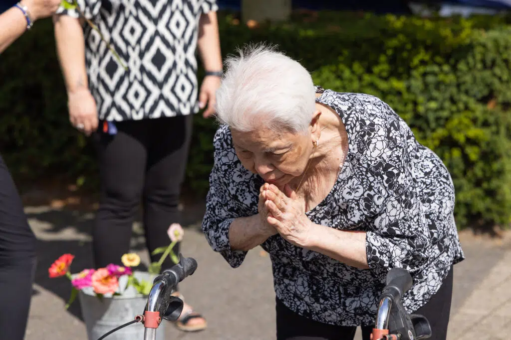 Oudere vrouw bidt bij Nusantara Herdenking met bloemen. Joep van Drunen Photography-349-van-385.jpg, Joep van Drunen Photography