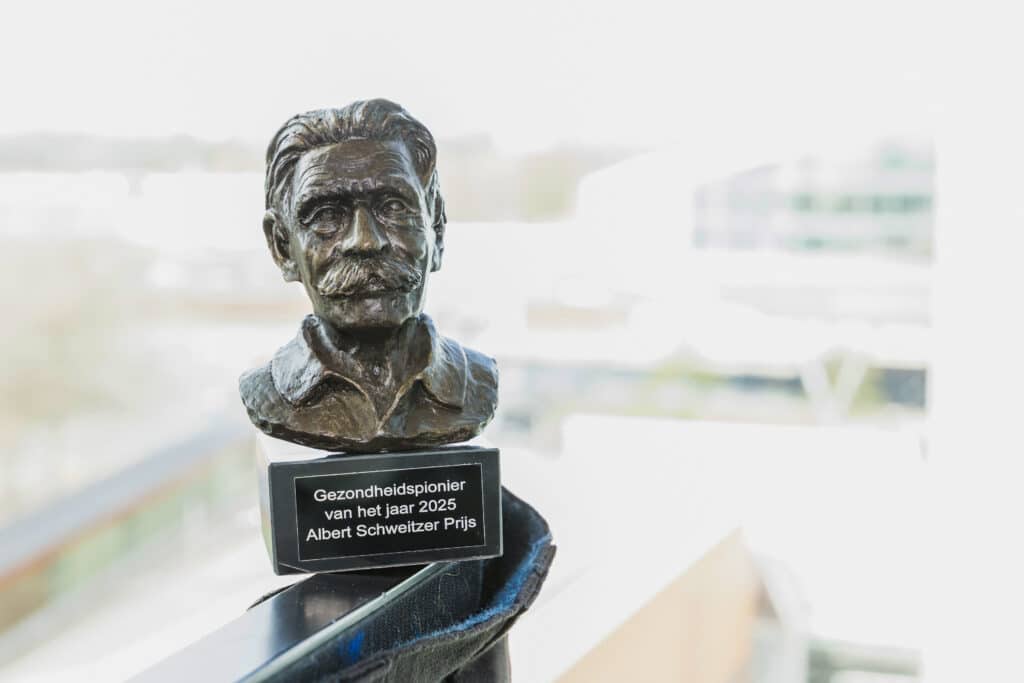 Eventfotografie Albert Schweitzer Fonds Bronzen buste 'Gezondheidspionier van het jaar 2025 Albert Schweitzer Prijs', op een reling. Joep van Drunen Photography